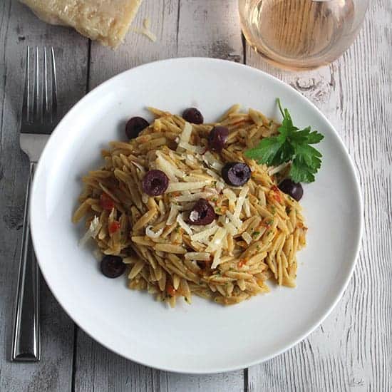 plate with orzo tossed with Provencal Pesto and topped with olives and cheese.