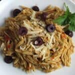 plate with orzo topped with provencal pesto and olives.