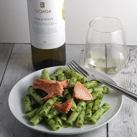 plate with salmon pesto pasta served with white wine from Navarra Spain.