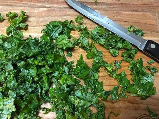 kale being chopped on a cutting board. 
