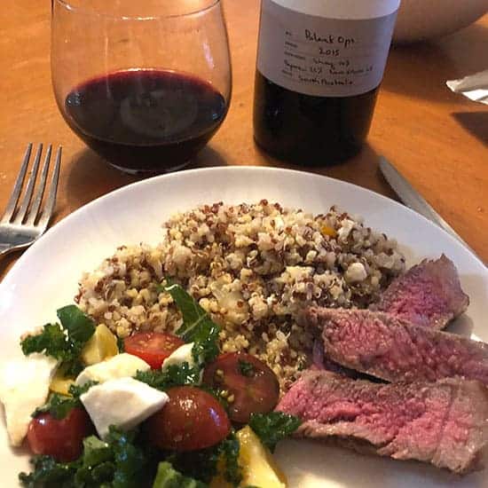 steak on a plate with salad and quinoa