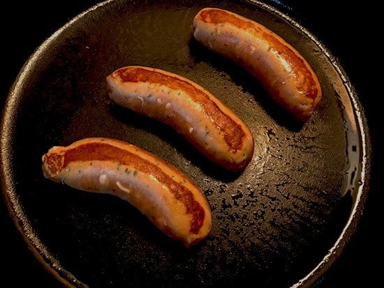 browning chicken sausages in a skillet
