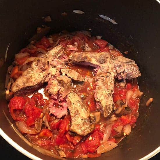 bones from leftover Porterhouse steak simmering in tomato sauce.