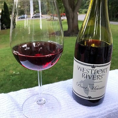 Bottle of Westport Rivers Pinot Meunier red wine, with a glass of it nearby.