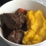 BBQ beef stew in a bowl with butternut puree.