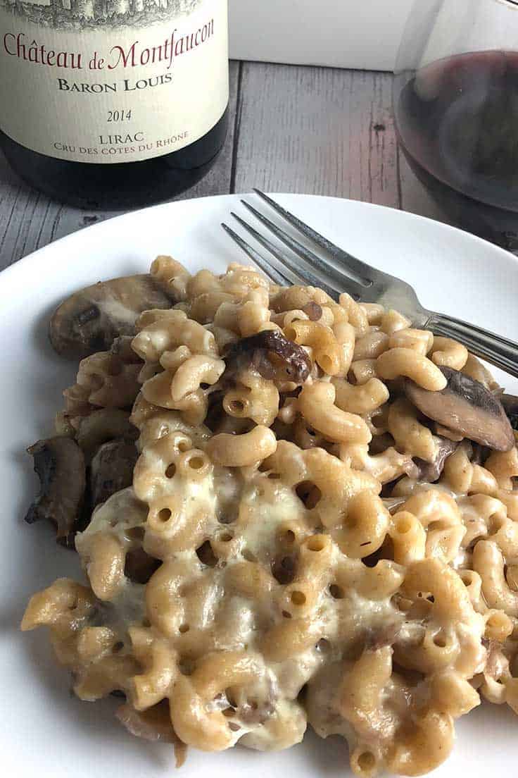 plate with mushroom mac and cheese casserole served with a red wine.