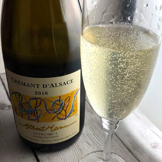 glass of Albert Mann Crémant d'Alsace next to the bottle.