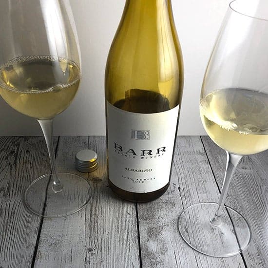 bottle of Barr Estate Albariño with two glasses of white wine.