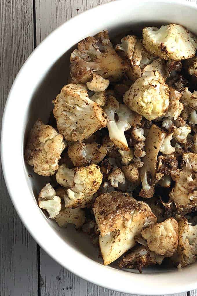 close up image of Indian roasted cauliflower in a bowl.
