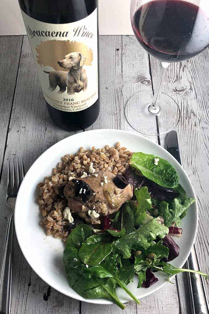 portobello mushroom chicken braise on a plate with farro and green salad.