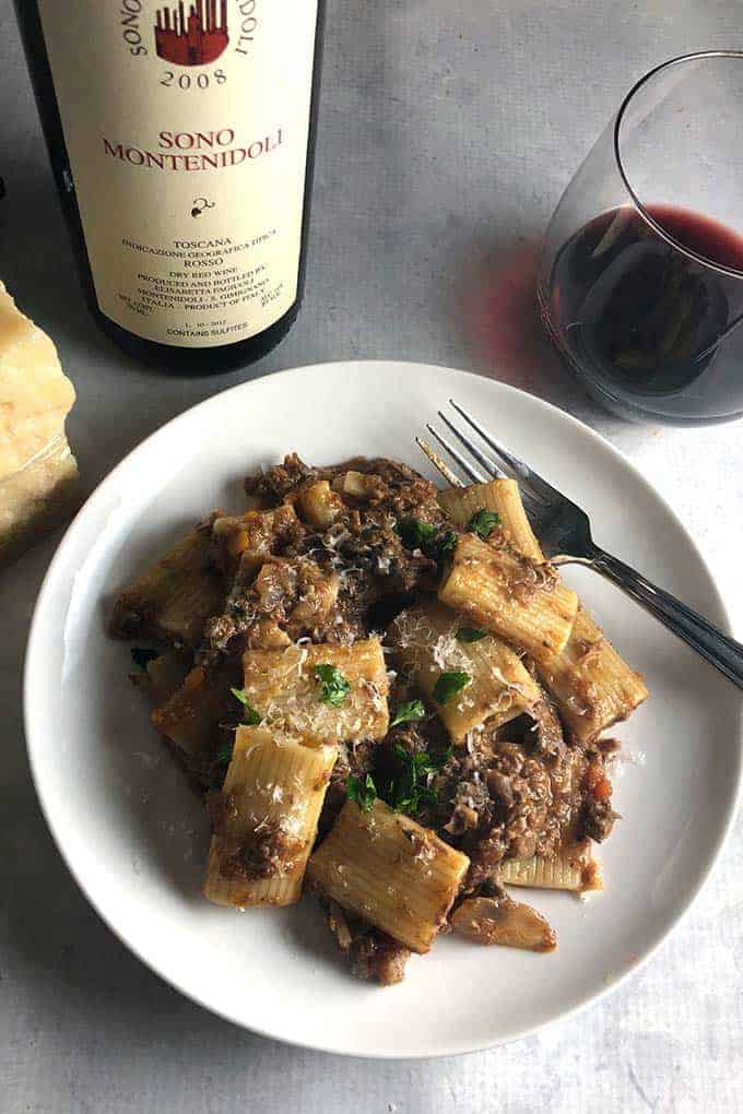 Short Rib Ragu on a plate, served with red Italian wine.