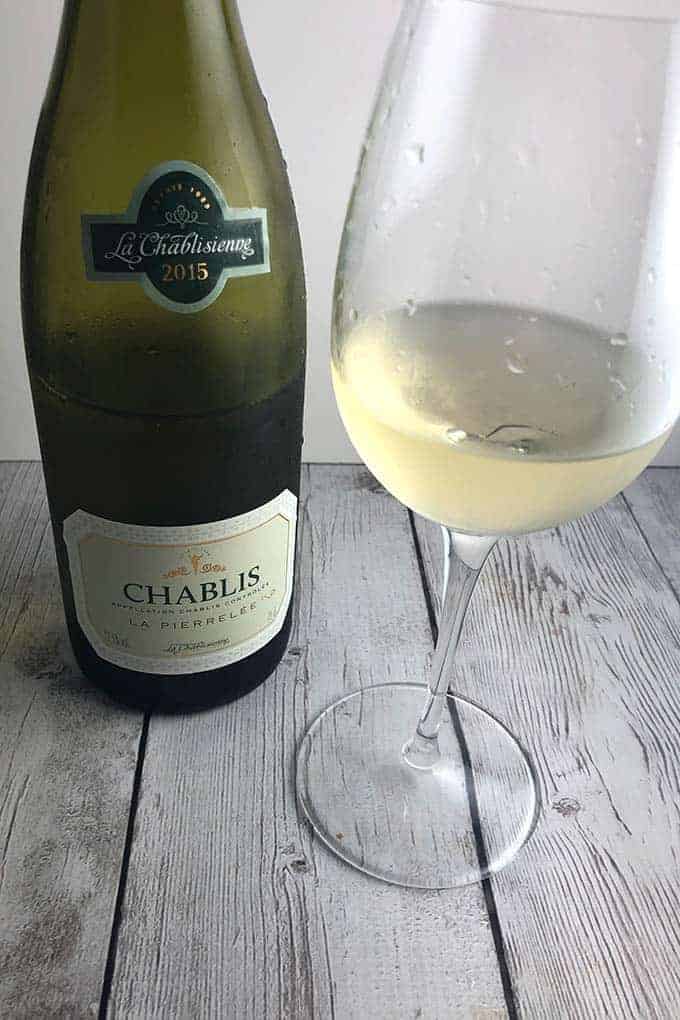 Bottle of Chablis wine with a glass poured.