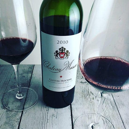 bottle of Chateau Musar red wine with two glasses poured.