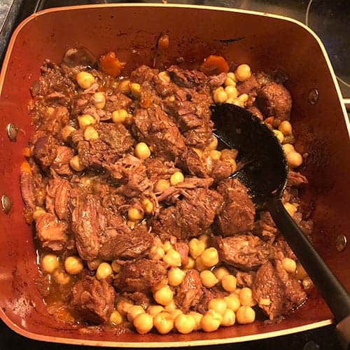 stirring chickpeas into beef and lamb tagine.