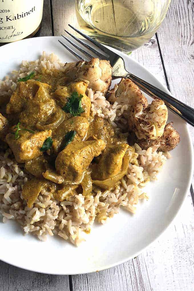 Indian Butter Chicken served with cauliflower and white wine.