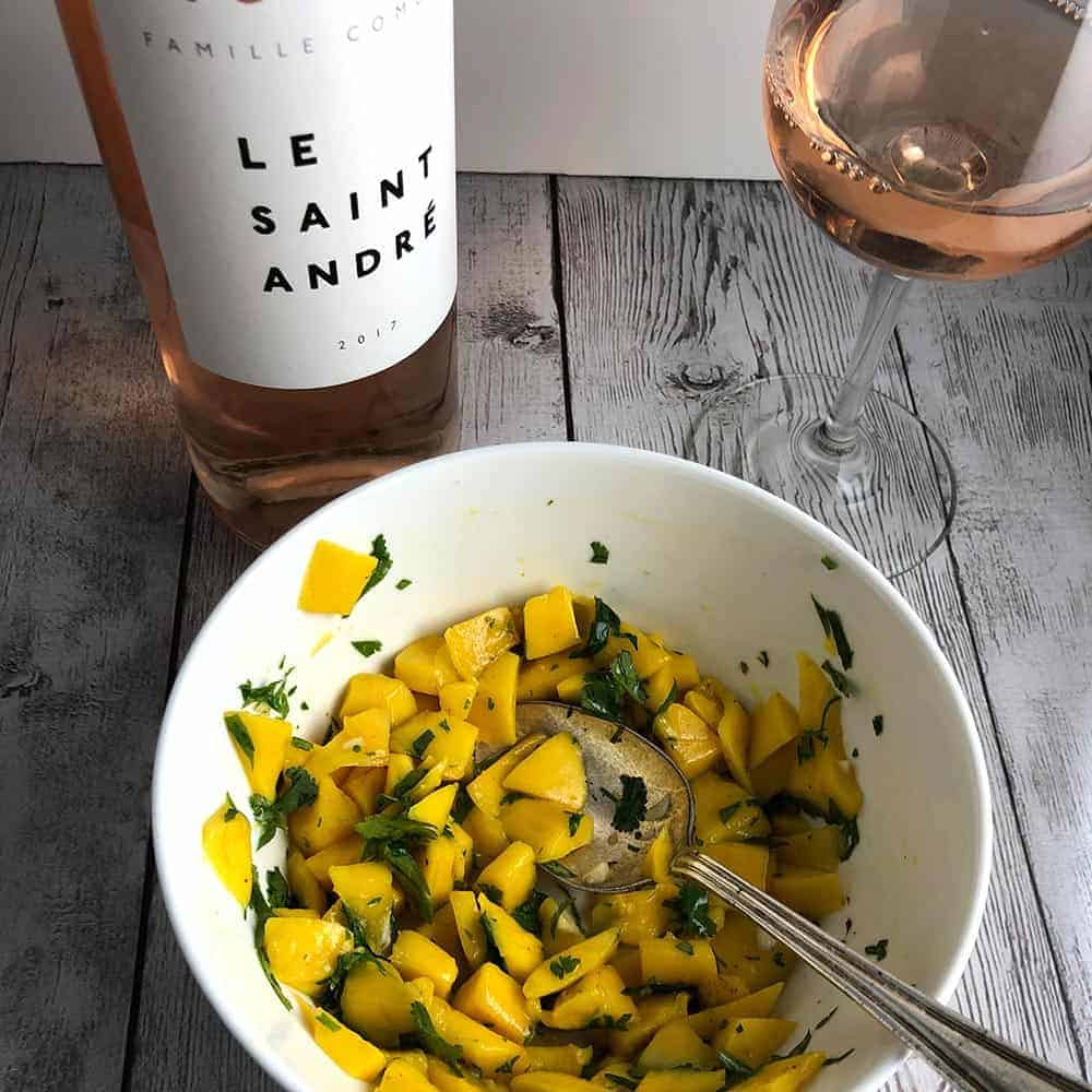 mango salsa in a bowl with rosé wine pairing.