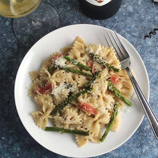 roasted asparagus pasta on a plate with white wine.