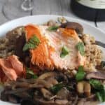 Salmon with farro and mushrooms on a plate.