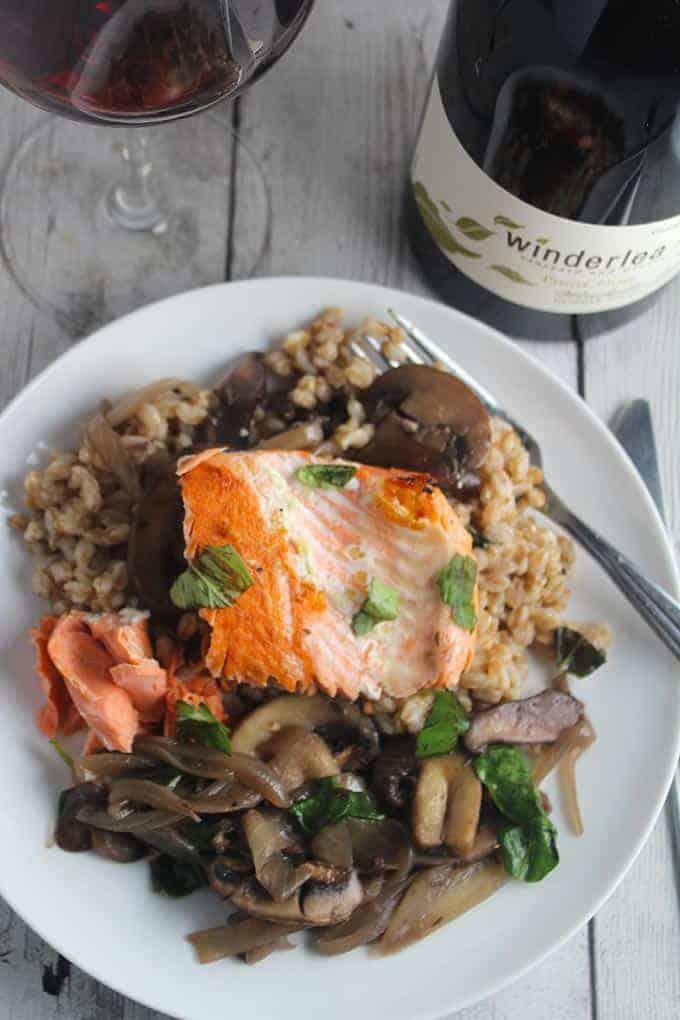 salmon with farro and mushrooms on a plate, served with Pinot Noir.