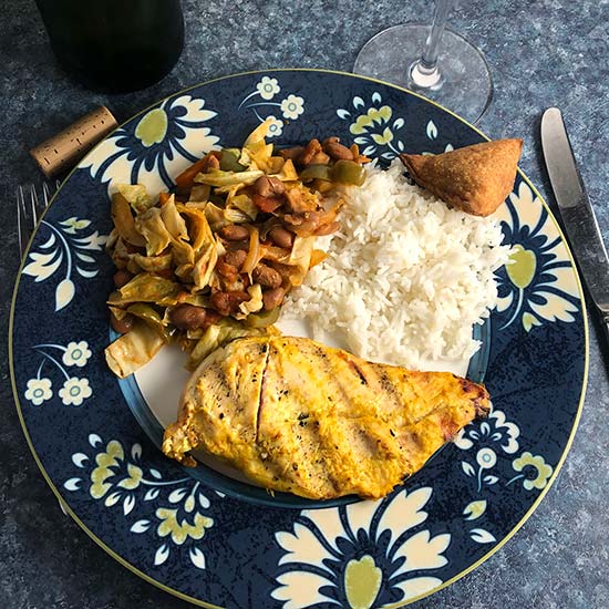 south african chicken on a plate with chakalaka and rice.