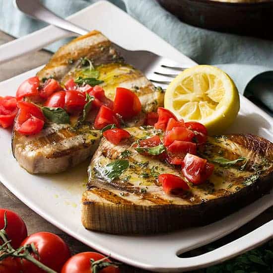 Grilled Sicilian Swordfish plated with tomatoes