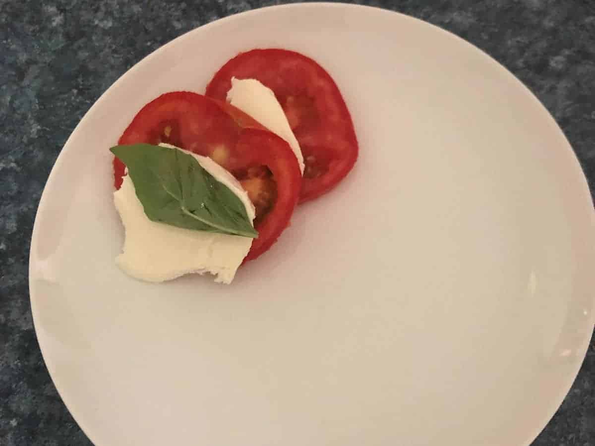making a tomato caprese salad