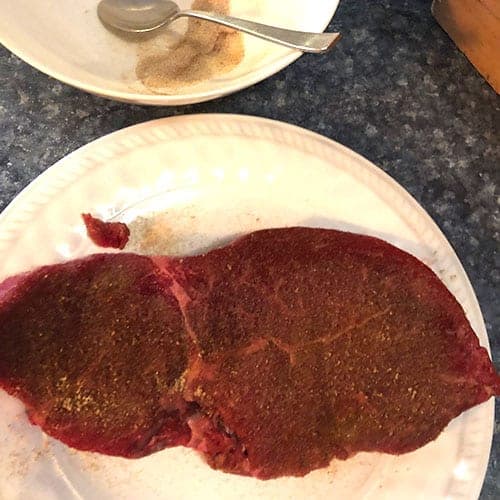 steak absorbing spice rub on a plate.