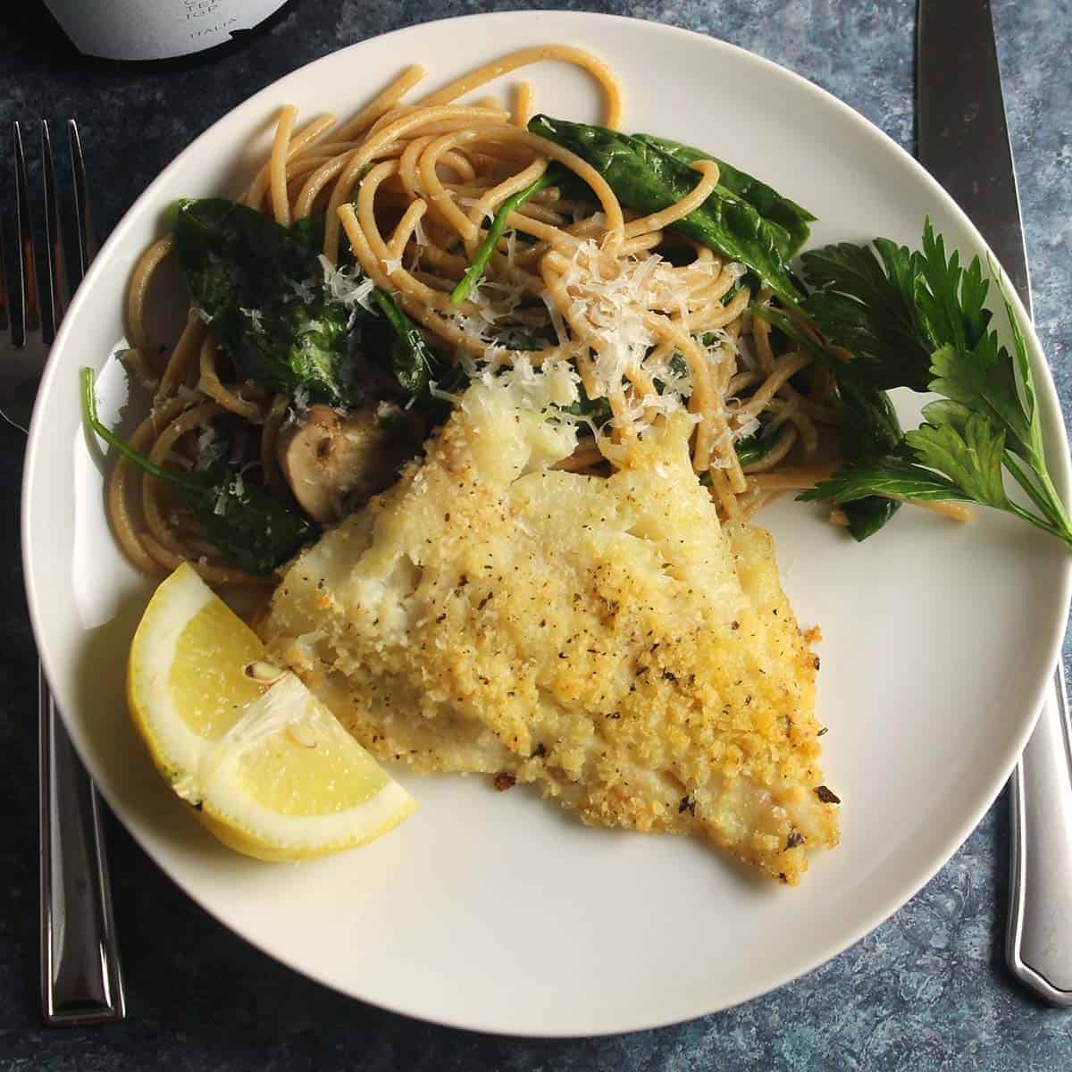 baked haddock on a plate with pasta.