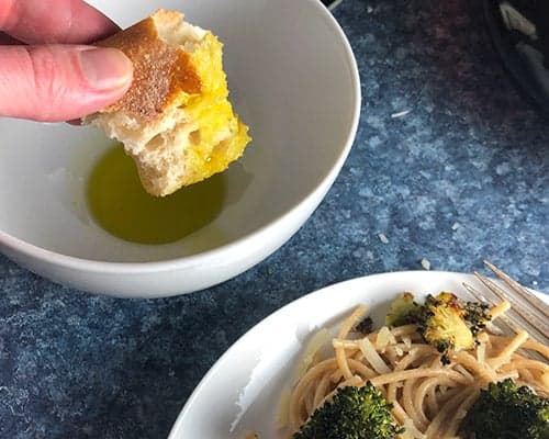 dipping bread into extra virgin olive oil