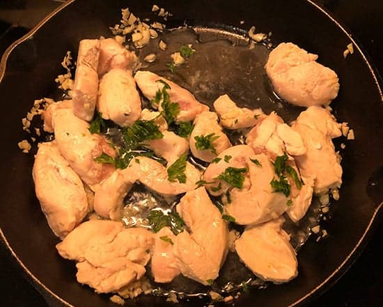 chicken and garlic in skillet with herbs