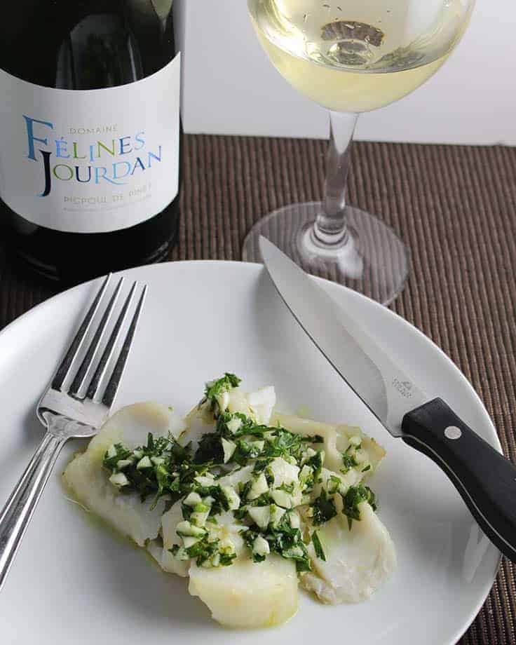 roasted cod with pesto served with white wine.