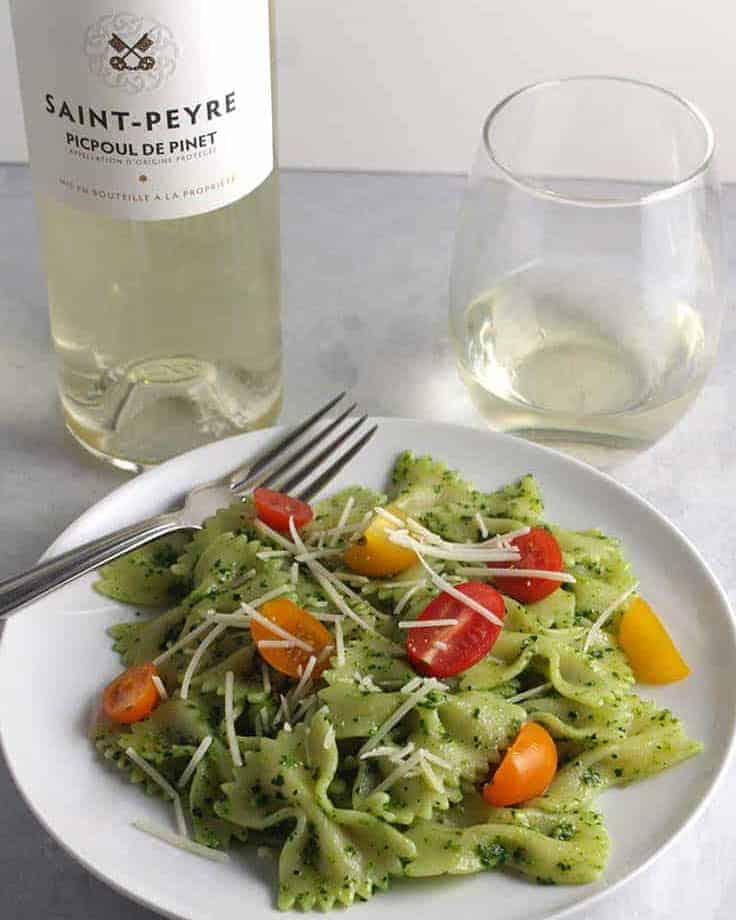 kale pesto pasta with a bottle of Picpoul