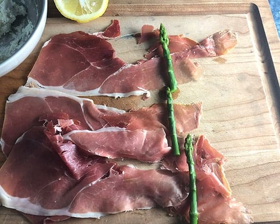 asparagus and prosciutto on cutting board.