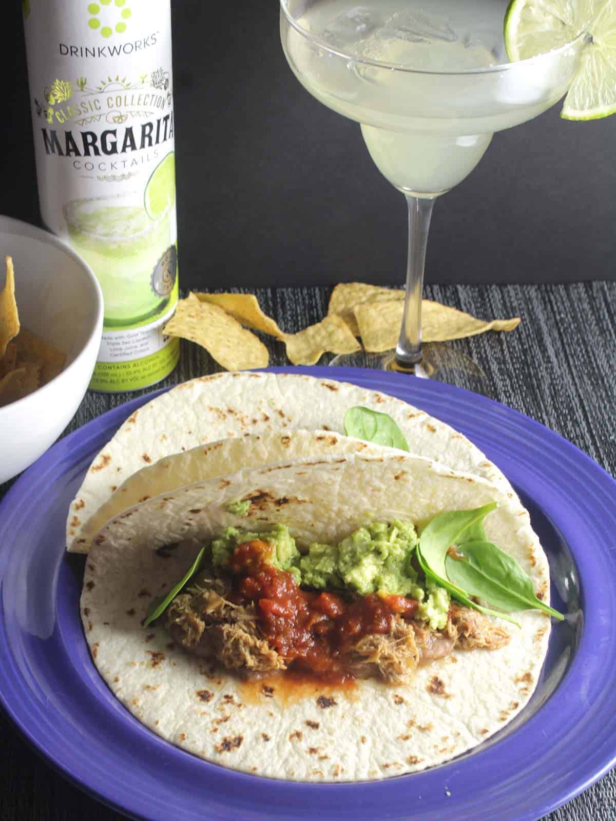 chicken tacos plated along with a margarita.