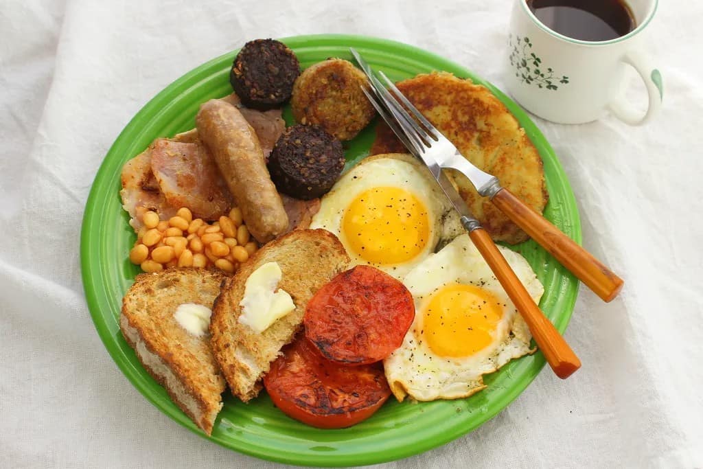 A plate with a full Irish breakfast, including eggs, sausage, toast and tomatoes.