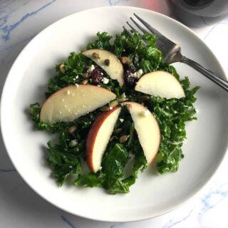 kale and apple salad served on a white plate.