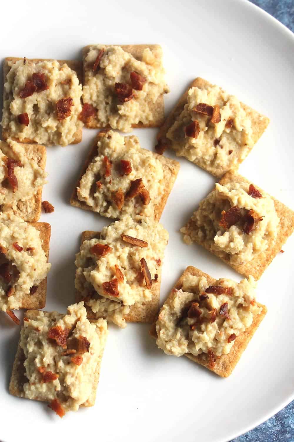 closeup of cauliflower bacon spread on crackers.