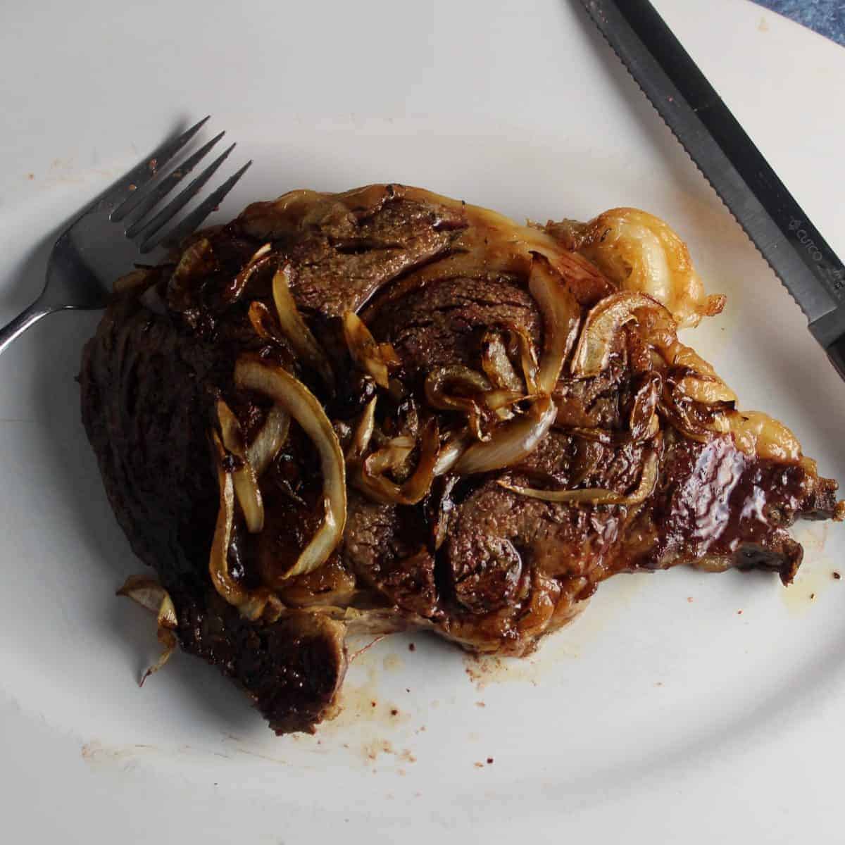 ribeye steak on platter ready to be cut.