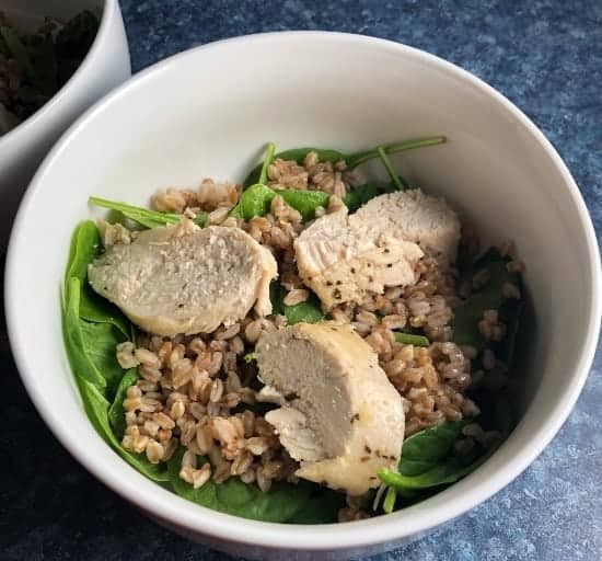 slices of chicken in a salad bowl with spinach.