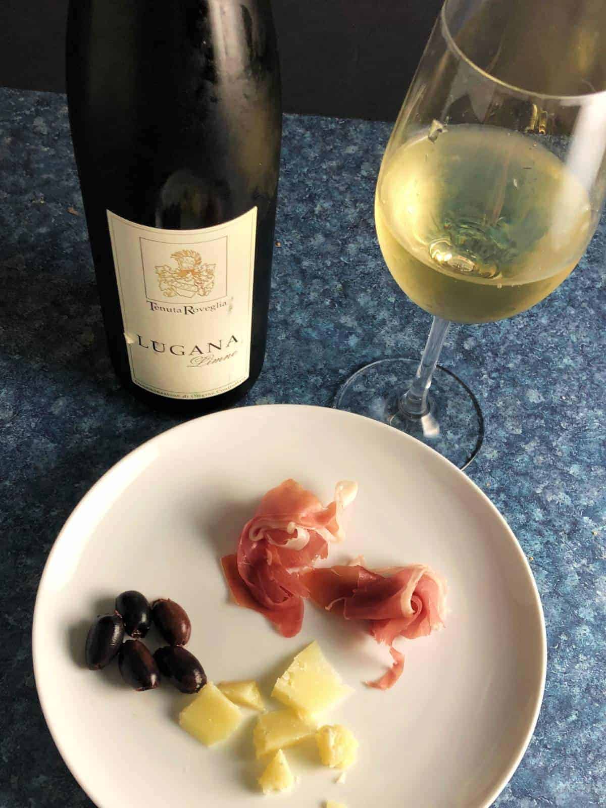 cheese plate with prosciutto paired with white wine.