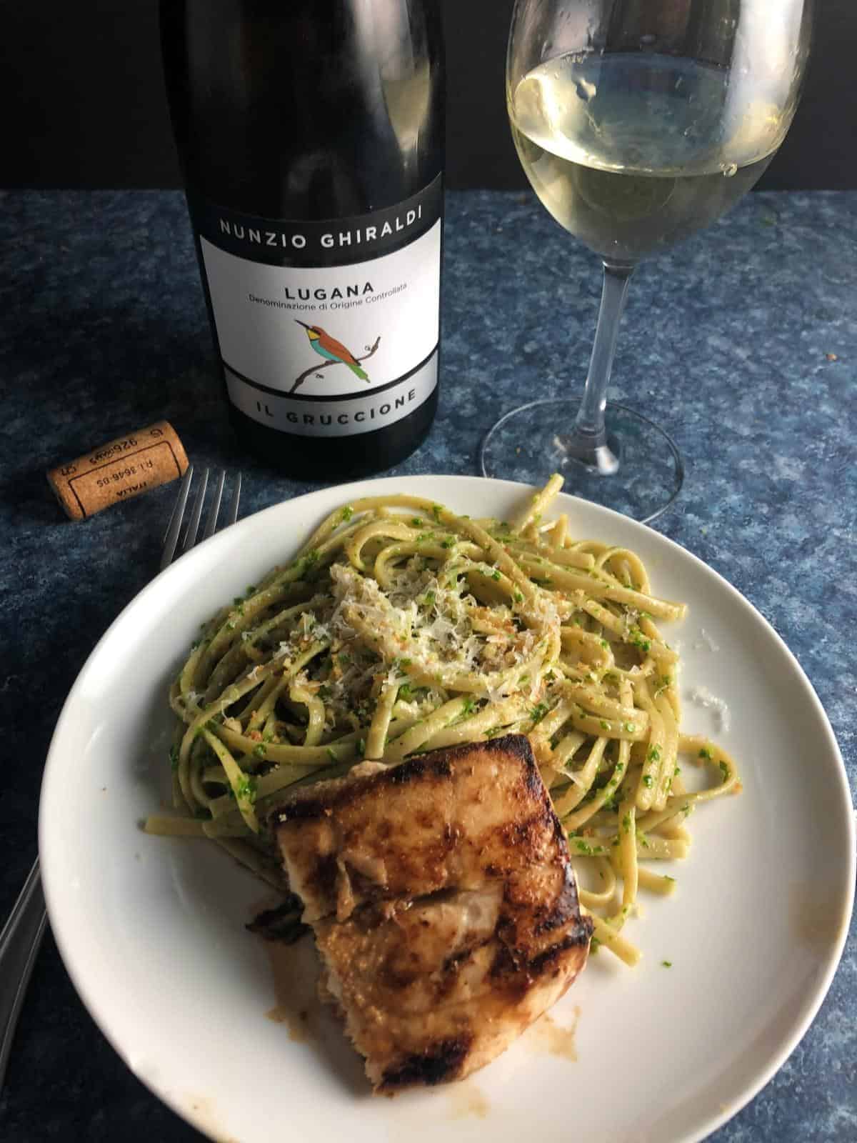 mahi mahi and pasta served with a white wine.