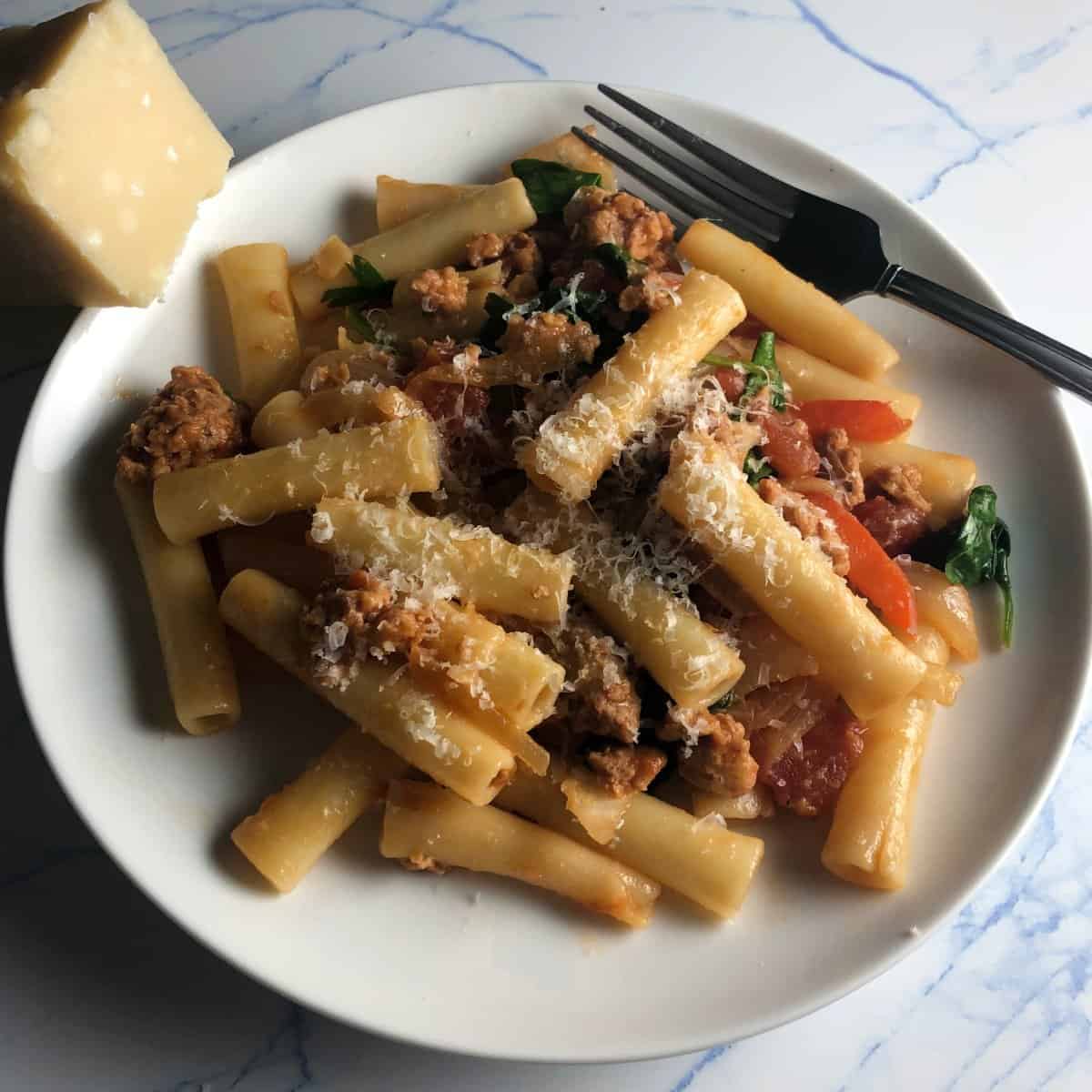 vegetarian sausage pasta on a white plate.