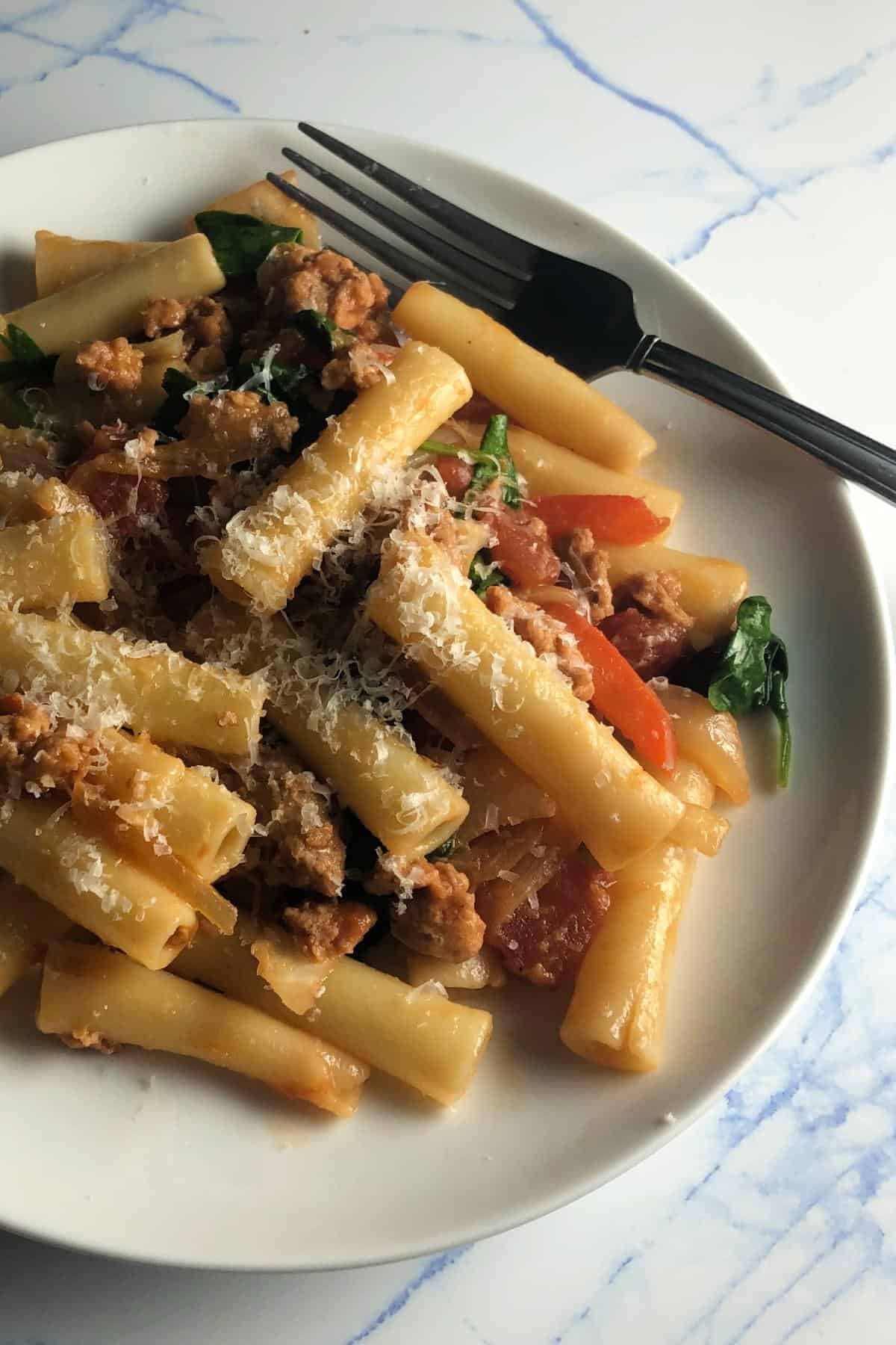 vegetarian sausage pasta on a white plate.