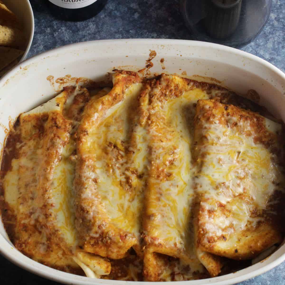beef and bean enchiladas with chipotle sauce and melted cheese.