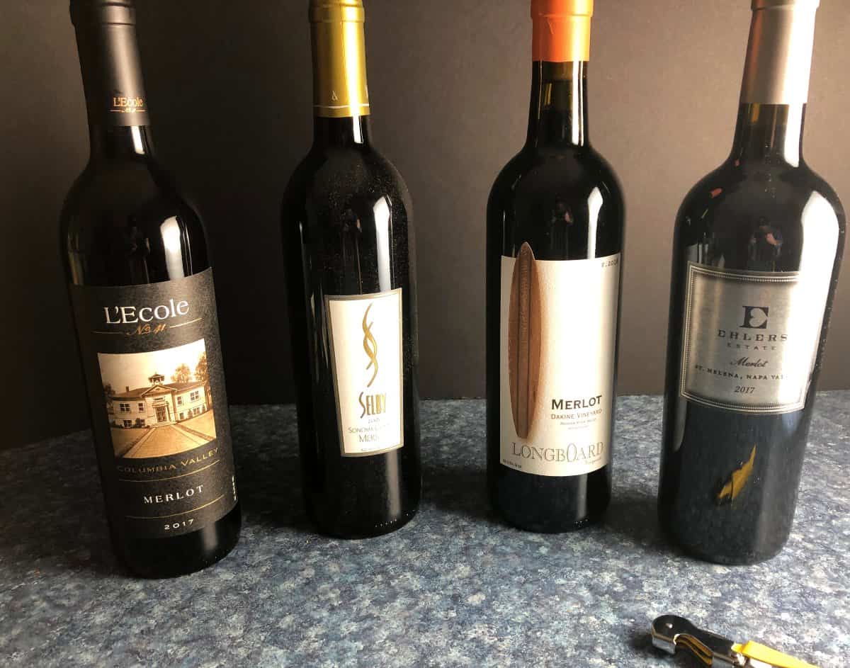 lineup of four bottles of Merlot wine.