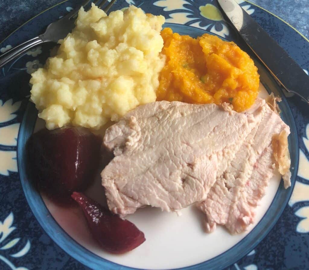 mashed butternut squash plated with turkey, potatoes and cranberry sauce.