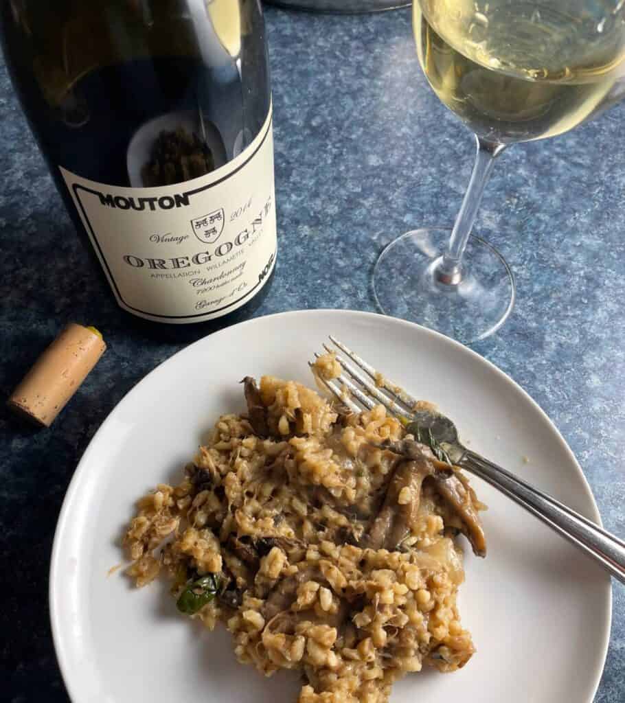 Pulled pork risotto on a white plate served with Oregogne Chardonnay.