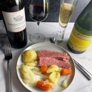 corned beef and cabbage dinner served with a red wine and a sparkling wine.