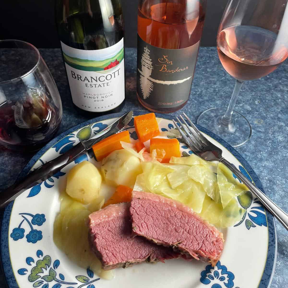 plate of corned beef and cabbage served with a rosé wine and a Pinot Noir.