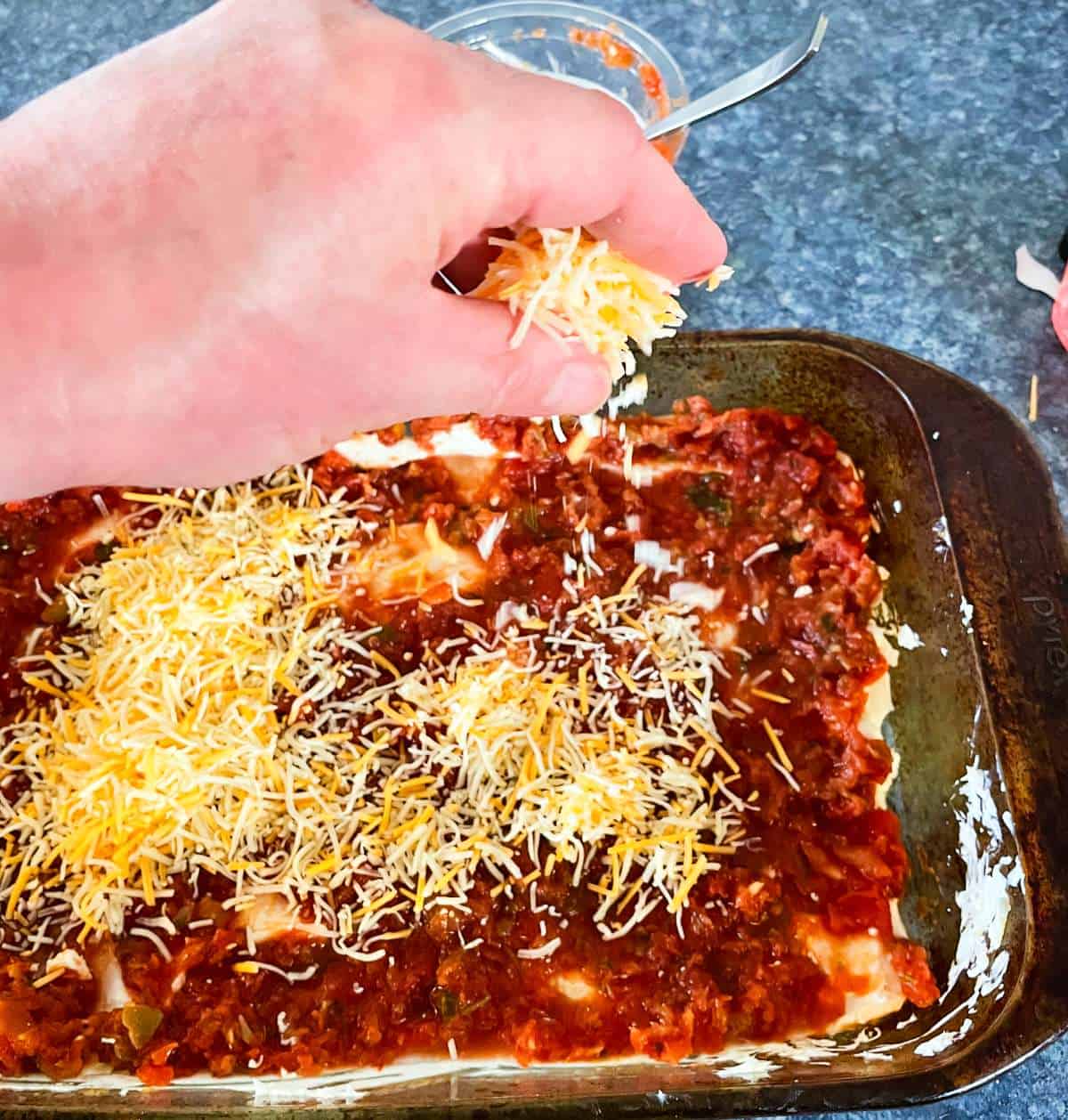 sprinkle shredded cheese over al layer of salsa to make Mexican dip